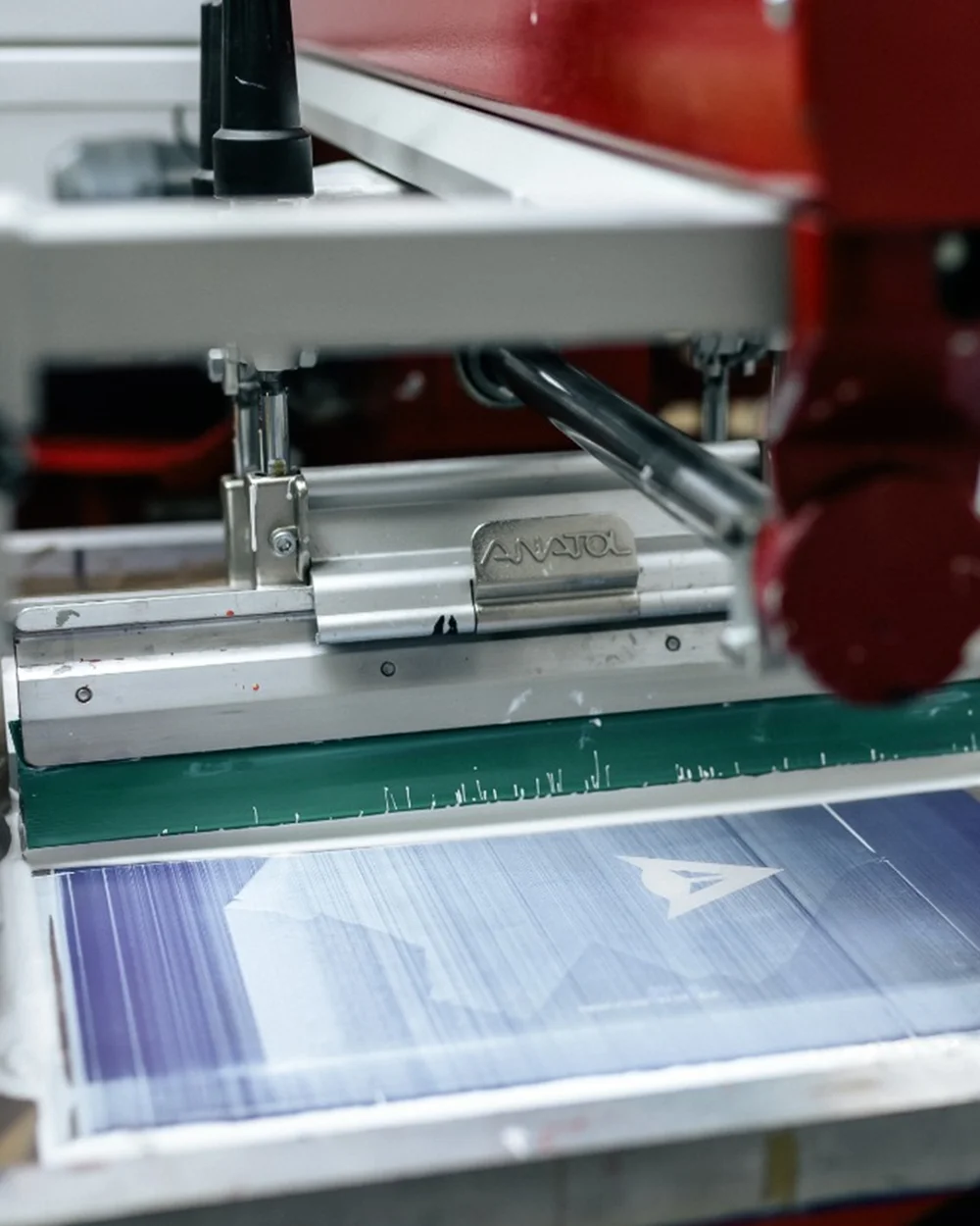 Cap de raclă Anatol pe mașina de serigrafie în timpul transferului de cerneală pe material imprimat cu logo - Antel Print