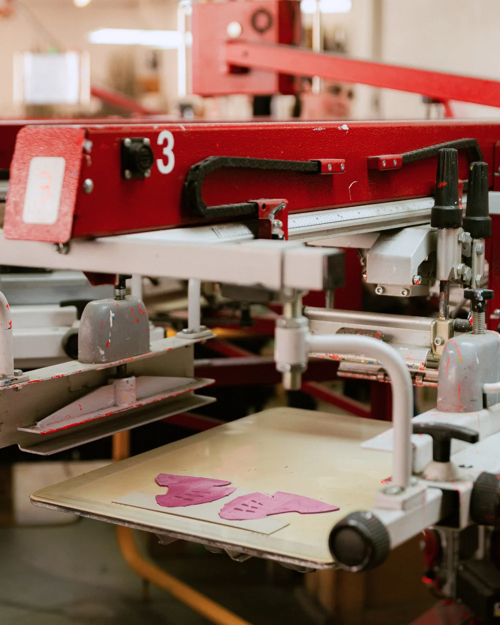 Mașină serigrafie industrială cu piese roz pe platou - Antel Print