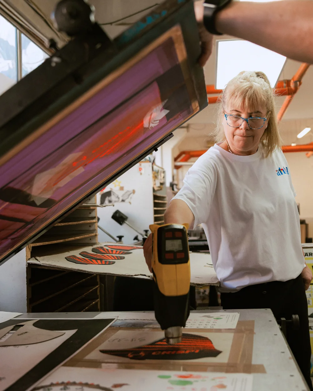 Operator Antel Print uscând cu aer cald piesele serigrafiate - Antel Print