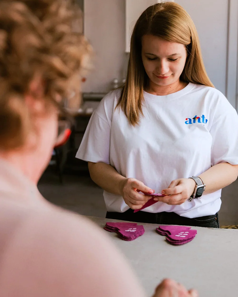 Operator Antel Print verificând piese serigrafiate roz - Antel Print