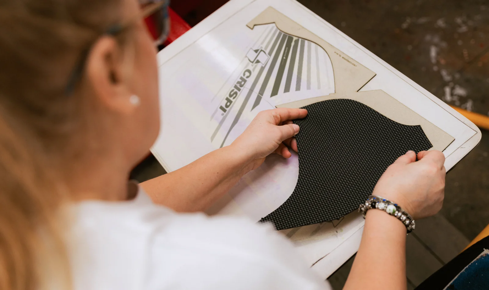 Operator pozitionând piesa Crispi pe platoul de serigrafie - Antel Print