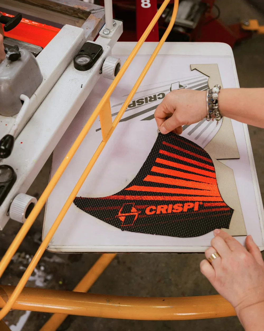 Operator ridicând piesă serigrafiat Crispi de pe platou - Antel Print